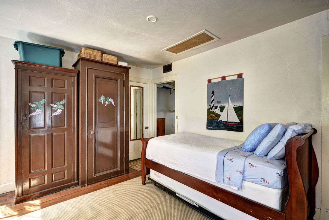 9 Bluff Point Lane Sag Harbor, NY 11963 - Photo 19 of 25 a bedroom with a bed and a mirror