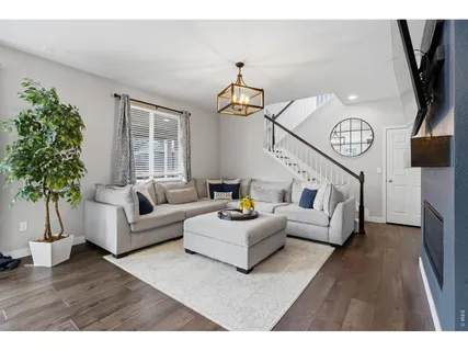 a living room with furniture a chandelier and a wooden floor