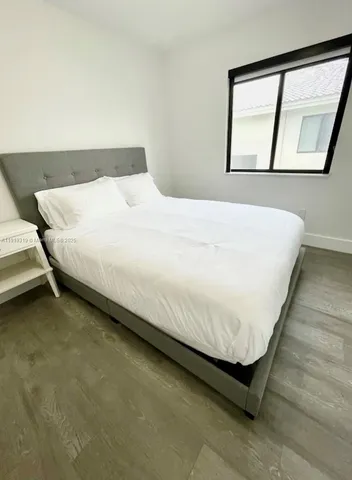 a large bed sitting in a bedroom next to a window