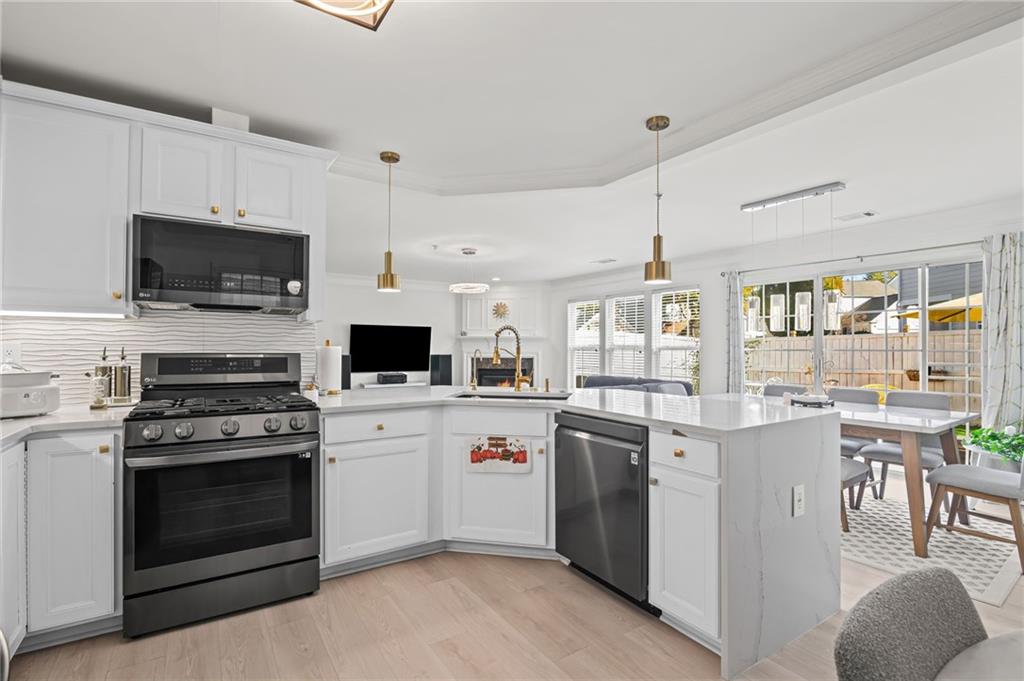 266 Balaban Circle Woodstock, GA 30188 - Photo 12 of 58 a kitchen with stainless steel appliances a stove top oven a sink dishwasher a refrigerator white cabinets and wooden floor