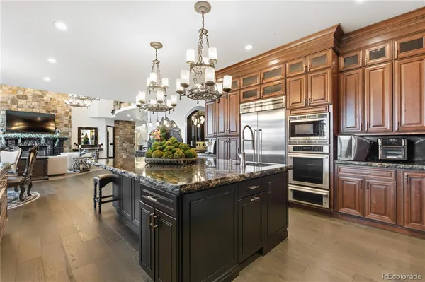 a kitchen with stainless steel appliances granite countertop a sink a stove and a refrigerator