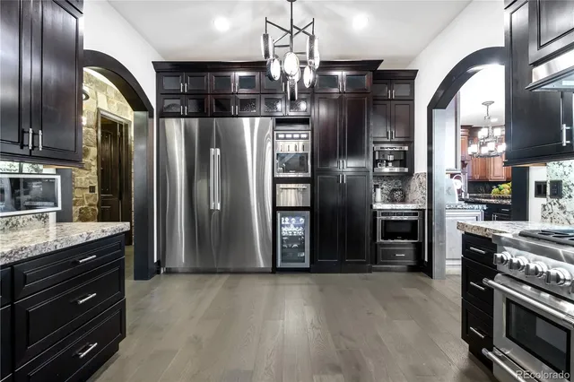a kitchen with stainless steel appliances granite countertop a refrigerator and a stove top oven