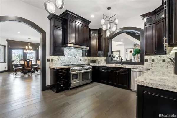 a large kitchen with stainless steel appliances granite countertop a stove and cabinets