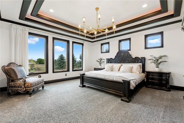 a spacious bedroom with a bed and a chandelier
