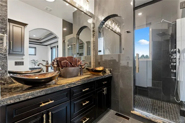 a bathroom with a granite countertop sink a large mirror and shower