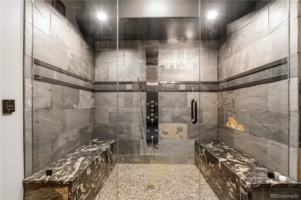a bathroom with mirror and shower