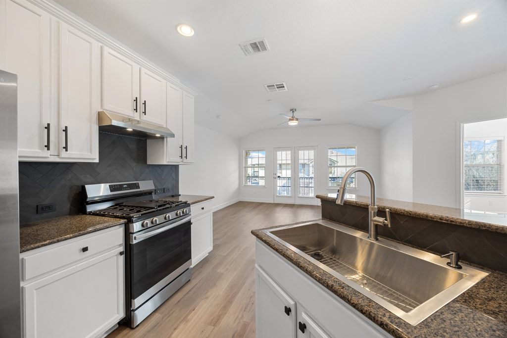 14815 Avery Ranch Boulevard, Unit 1701 Austin, TX 78717 - Photo 13 of 24 a kitchen with granite countertop a sink stainless steel appliances and cabinets