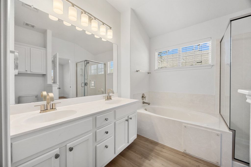 14815 Avery Ranch Boulevard, Unit 1701 Austin, TX 78717 - Photo 20 of 24 a bathroom with a tub a sink double vanity and mirror