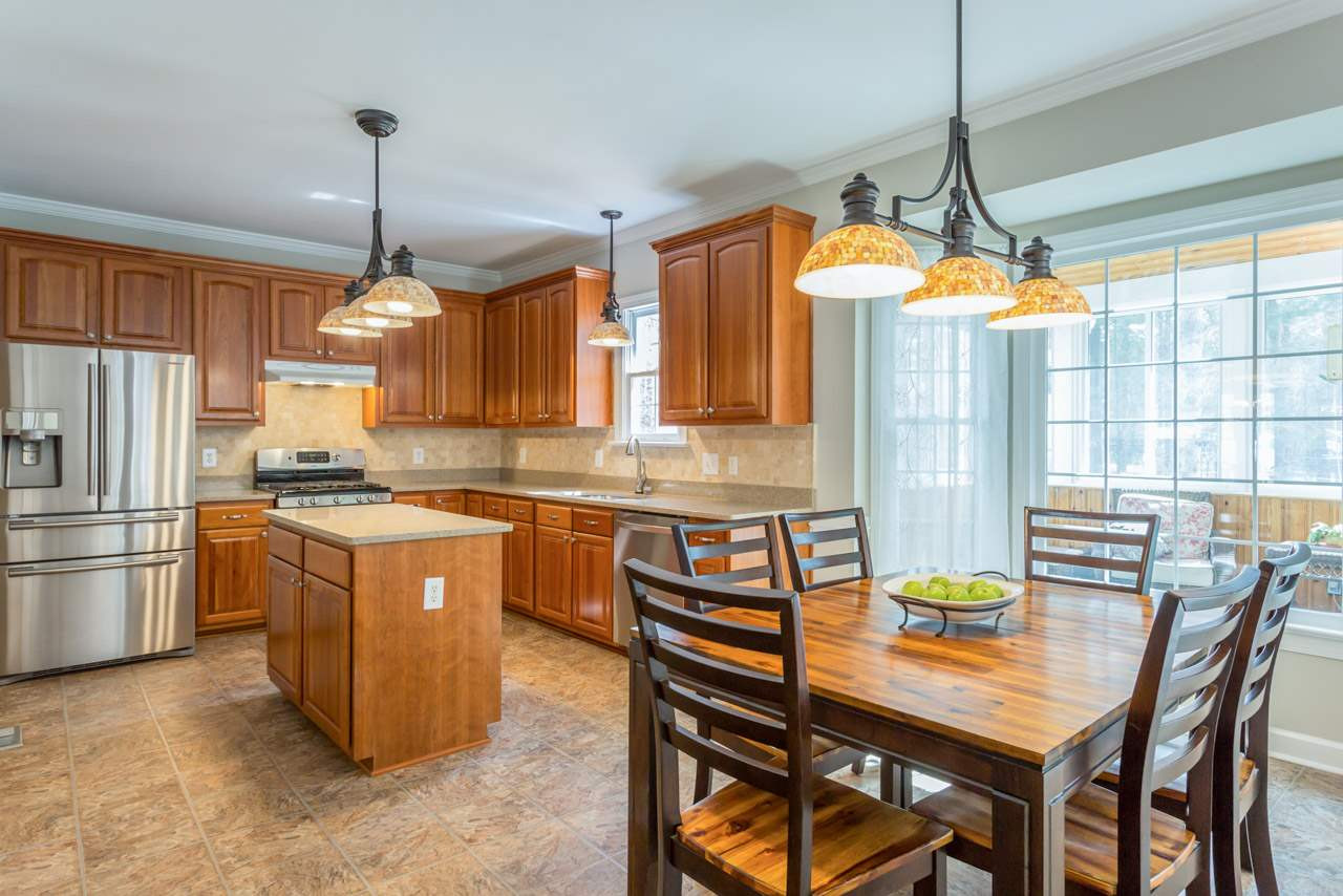 5600 Crossfield Drive Raleigh, NC 27613 - Photo 6 of 25 The open, remodeled kitchen offers stainless appliances, abundant cabinet storage, and a tile backsplash. There are glass cabinet doors above the kitchen desk. This room has also just been freshly painted. Remodeled Kitchen