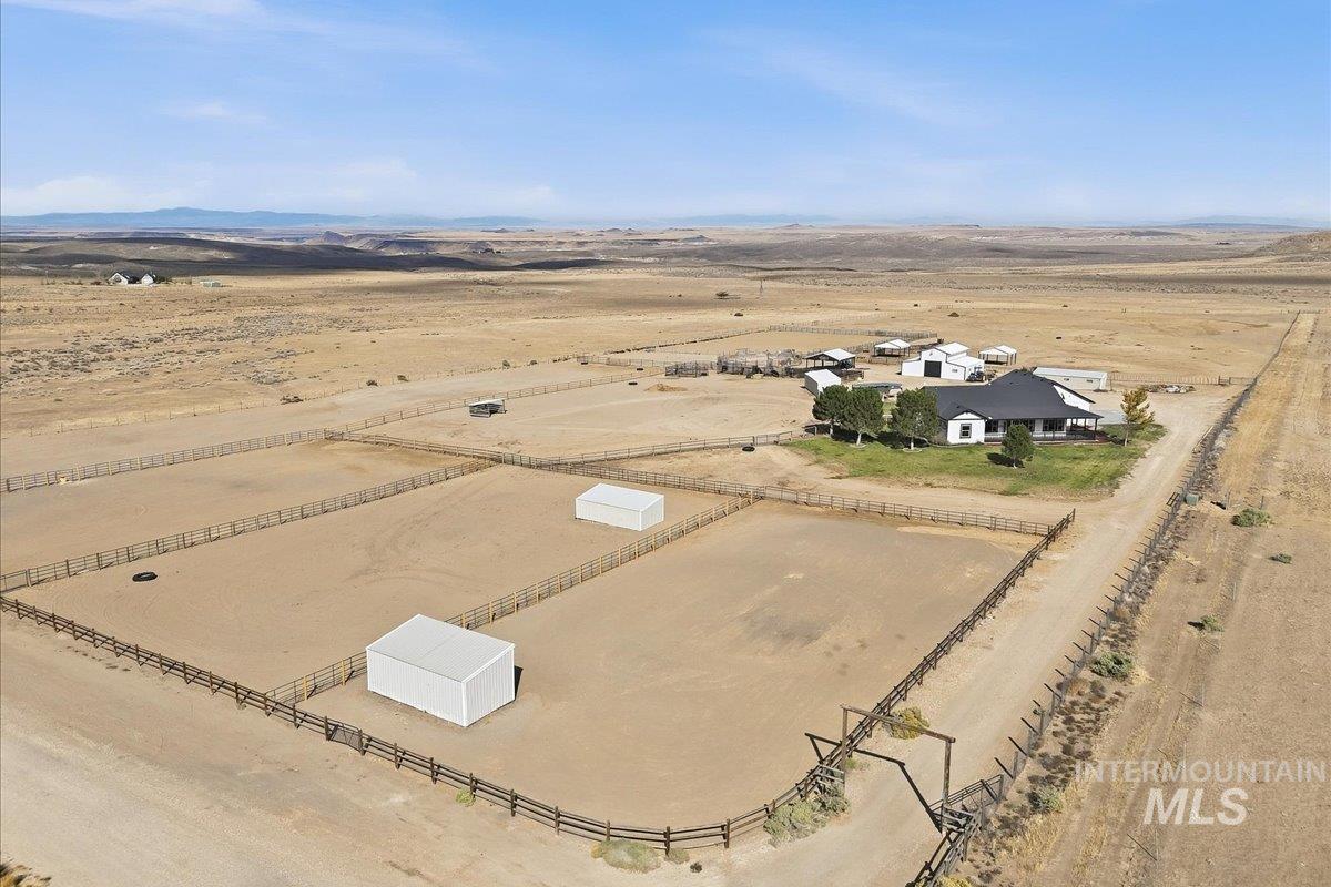 18026 Briar Creek Road Murphy, ID 83650 - Photo 50 of 50 Expansive property featuring multiple fenced enclosures, a white single-story residence with a dark roof, and multiple outbuildings