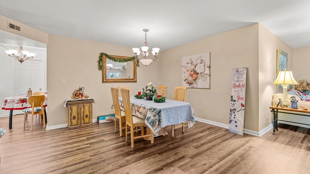 5548 Spring Brook Road, Unit 310 Rockford, IL 61114 - Photo 15 of 41 a view of a dining room with furniture wooden floor and chandelier
