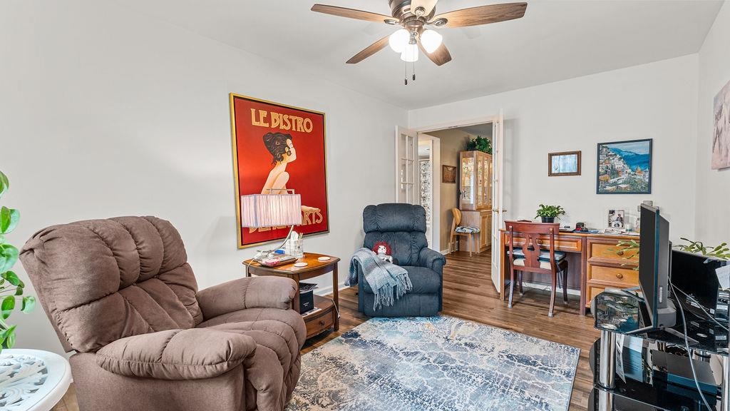 5548 Spring Brook Road, Unit 310 Rockford, IL 61114 - Photo 31 of 41 a living room with furniture a wooden floor and a flat screen tv