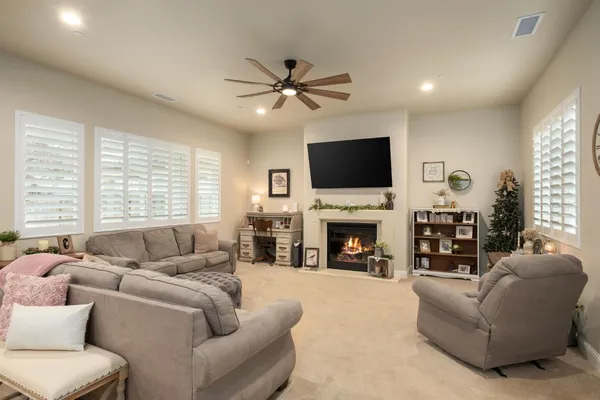 a living room with furniture kitchen area and a large window