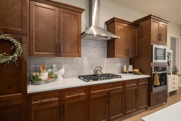 a kitchen with a sink a counter top space appliances and a living room view