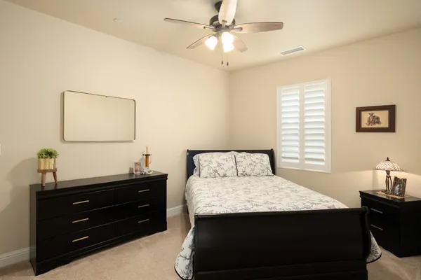 a bedroom with a bed a book shelf and a window