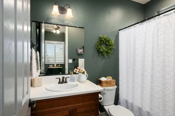 a bathroom with a sink vanity mirror and toilet