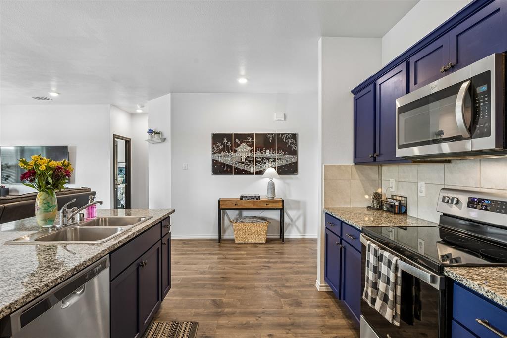 802 Rustic Way Royse City, TX 75189 - Photo 24 of 38 a kitchen with stainless steel appliances granite countertop a stove a sink and a microwave