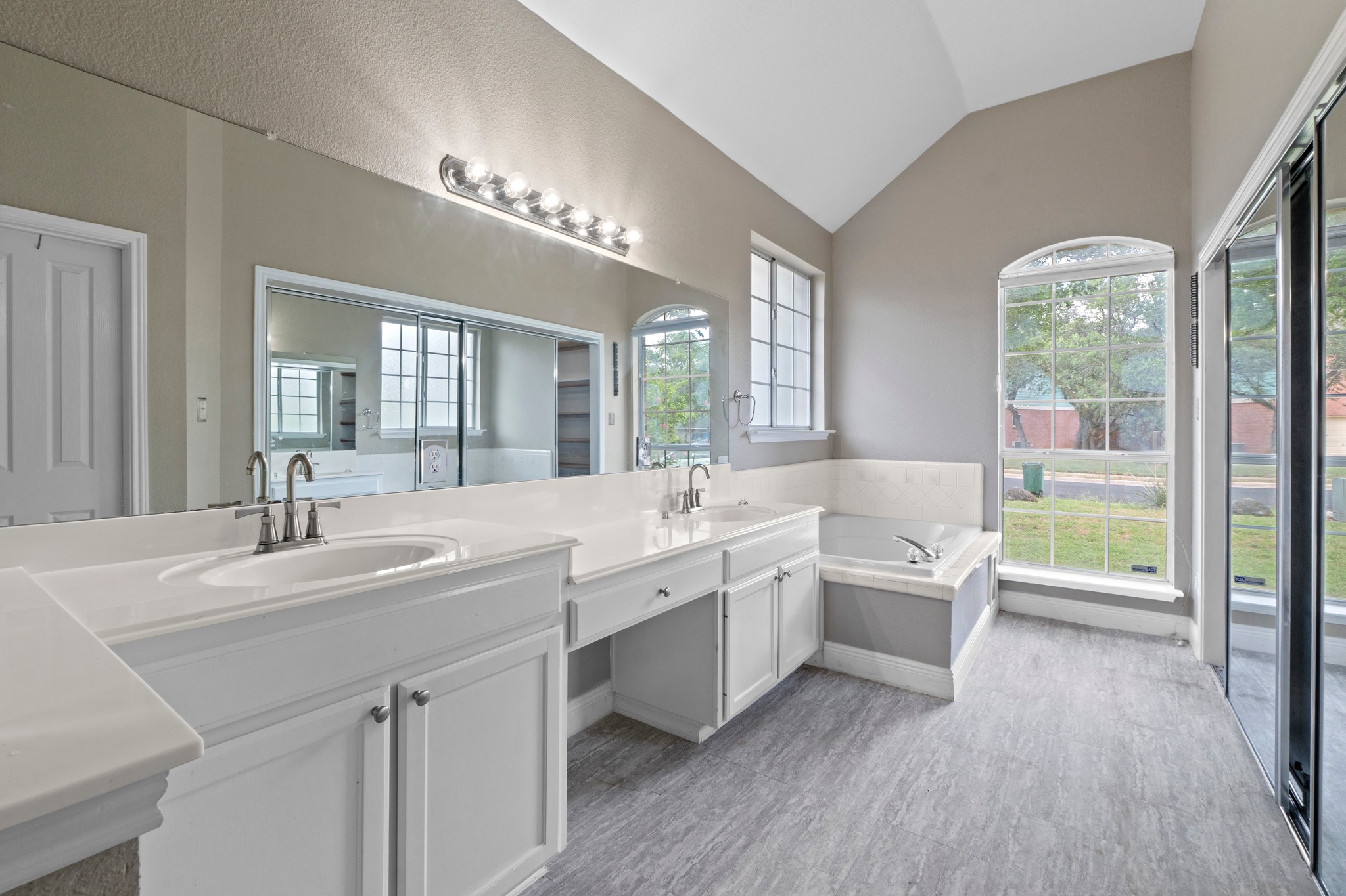 8605 Axis Drive Austin, TX 78749 - Photo 19 of 38 Dual vanities and a soaking tub provide a serene retreat in this well-lit primary bath.