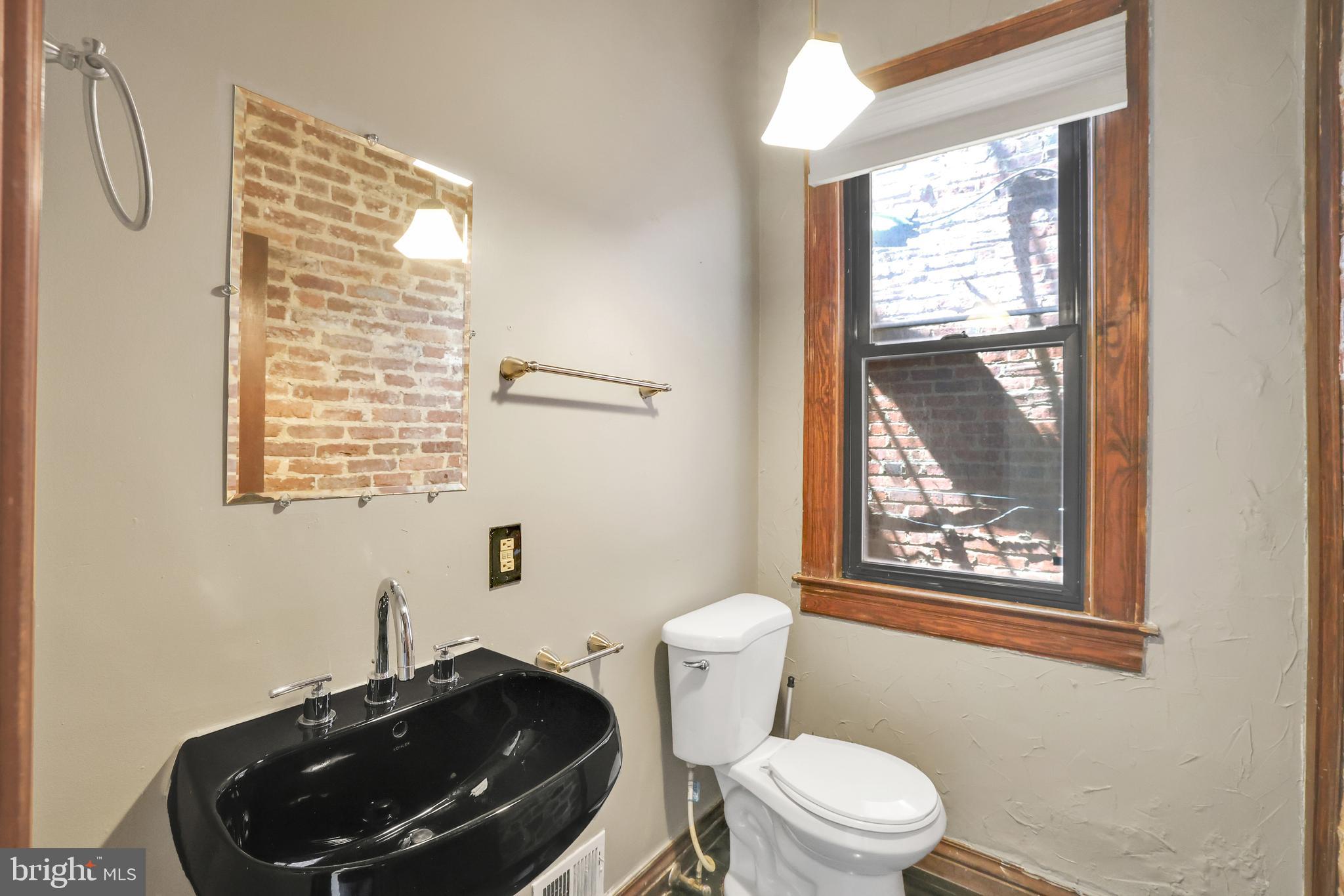 1828 California Street Northwest, Unit A Washington, DC 20009 - Photo 11 of 52 a bathroom with a toilet a sink and a mirror