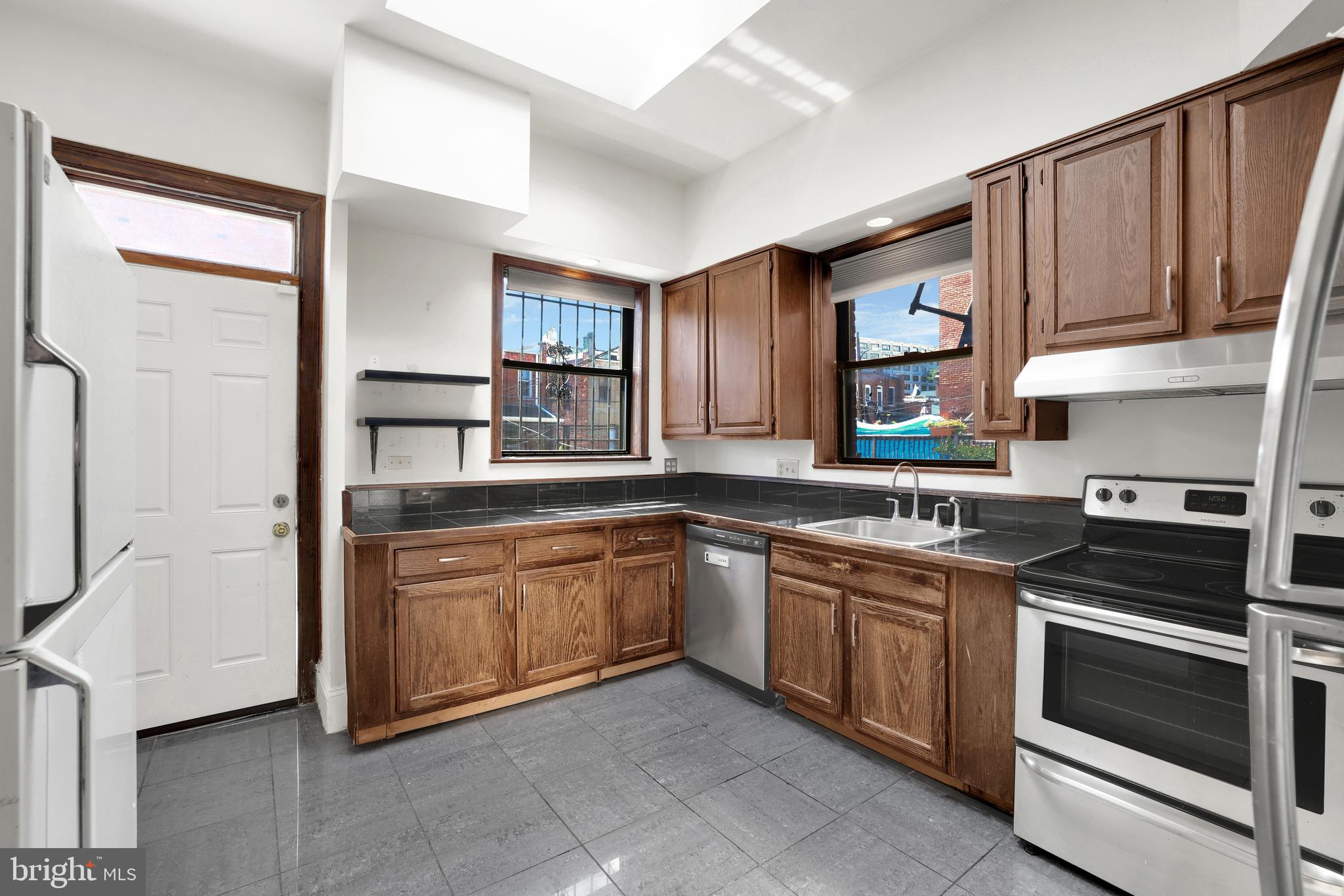 1828 California Street Northwest, Unit A Washington, DC 20009 - Photo 16 of 52 a kitchen with stainless steel appliances granite countertop a stove and a sink