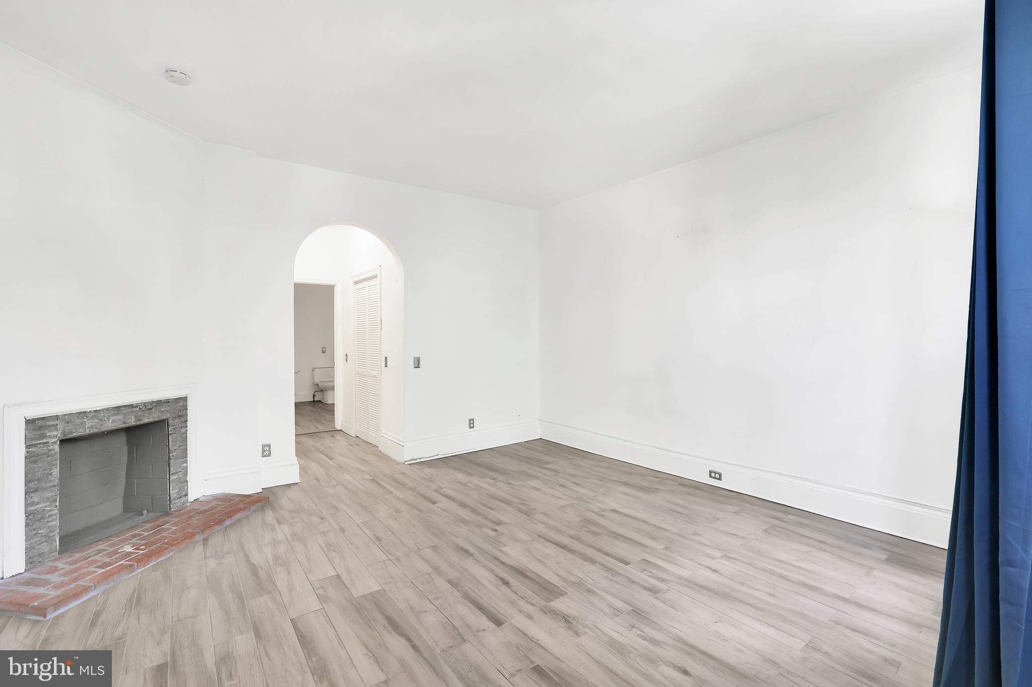 1828 California Street Northwest, Unit A Washington, DC 20009 - Photo 46 of 52 an empty room with a fireplace and wooden floor
