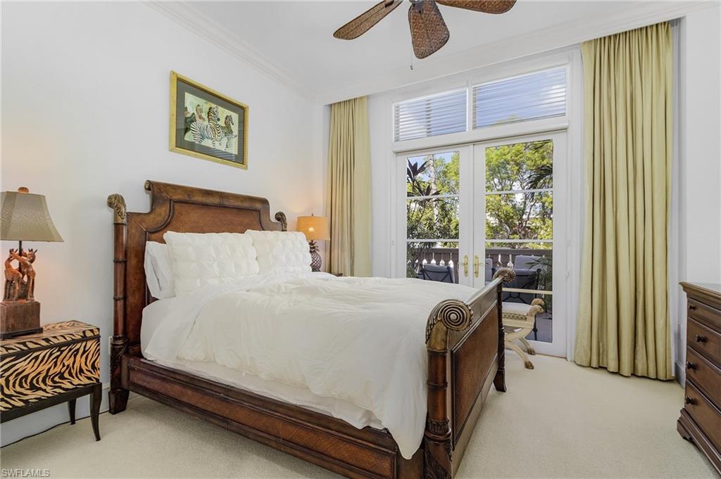 780 5th Avenue South, Unit 3 Naples, FL 34102 - Photo 20 of 28 a bedroom with a bed and a chandelier