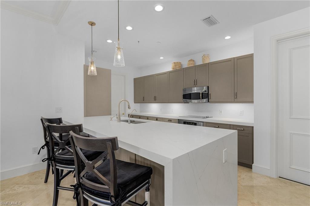 780 5th Avenue South, Unit 3 Naples, FL 34102 - Photo 4 of 28 a kitchen with stainless steel appliances granite countertop a stove a refrigerator a kitchen island a table and chairs