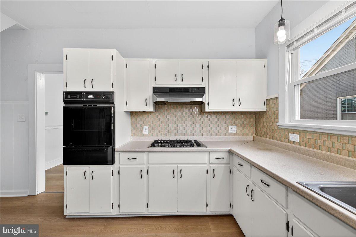 615 13th Street New Castle, DE 19720 - Photo 12 of 39 a kitchen with white cabinets and black appliances