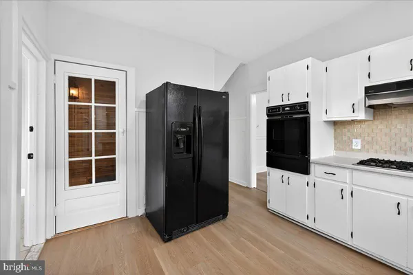 a kitchen with granite countertop white cabinets and refrigerator