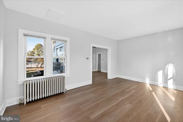 a view of a room with wooden floor and a window