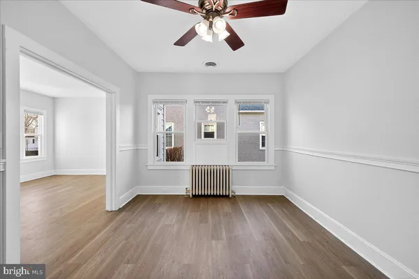 a view of empty room with wooden floor