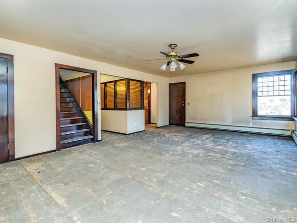 an empty room with windows and ceiling fan