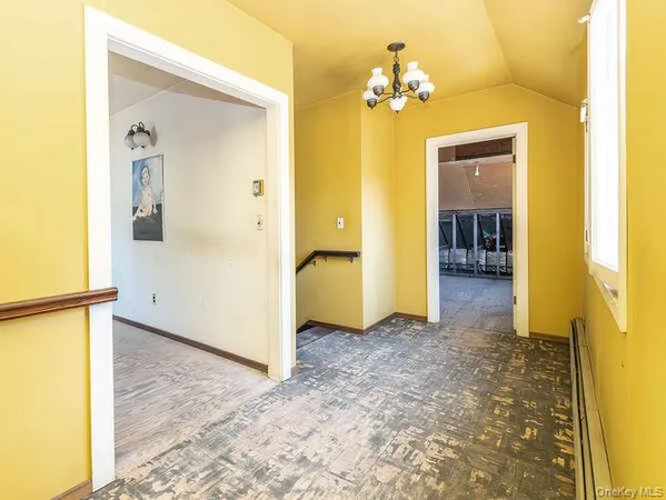 a view of a hallway with a chandelier and a livingroom