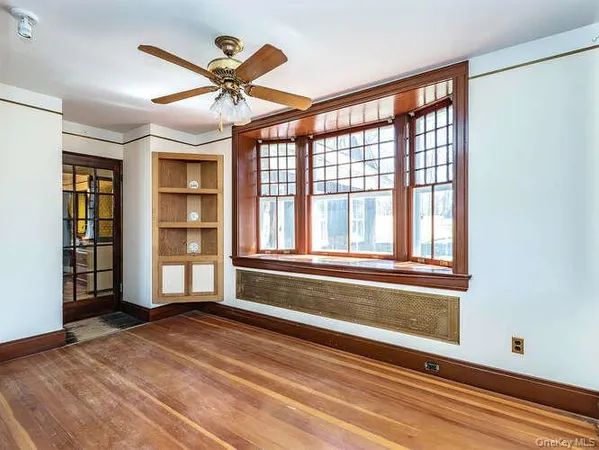 an empty room with windows and ceiling fan