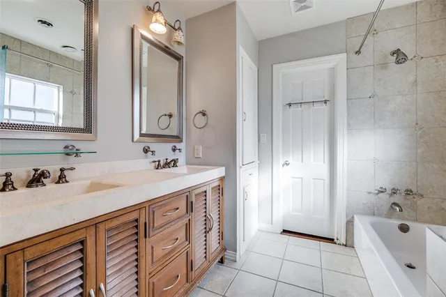 a bathroom with a granite countertop sink a mirror and shower