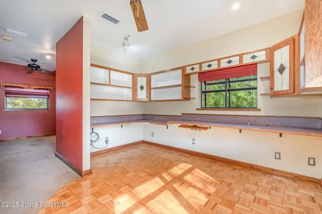 a view of a room with a ceiling fan and entryway