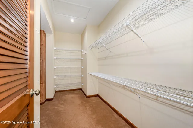 an empty room with closet and a chandelier fan