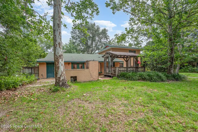 an aerial view of a residential houses with yard