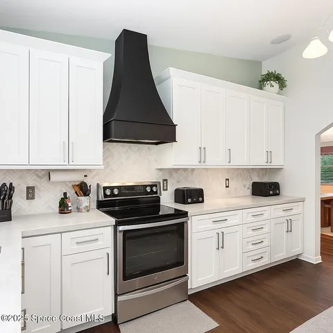 a kitchen with white cabinets and white appliances