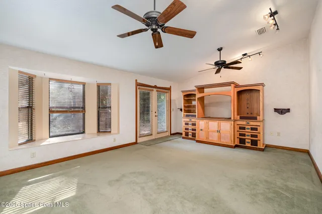 a view of a livingroom with furniture ceiling fan and windows