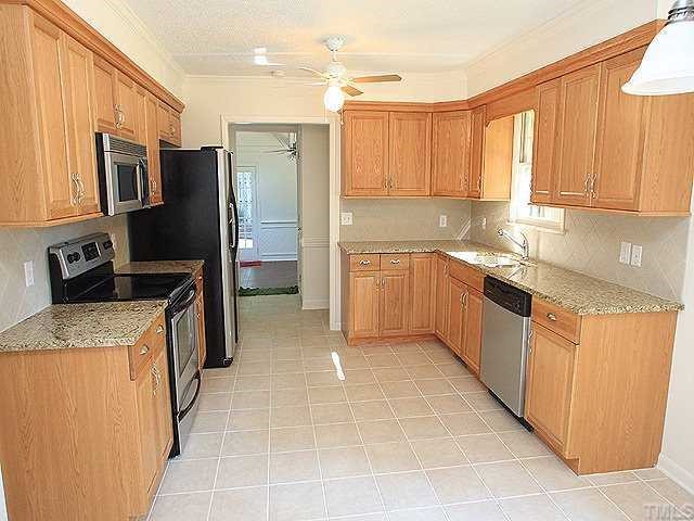 4001 Brevard Place Raleigh, NC 27609 - Photo 3 of 12 a kitchen with stainless steel appliances granite countertop a stove top oven a sink dishwasher a refrigerator and cabinets with wooden floor