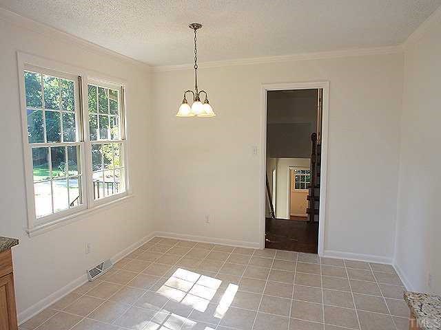 4001 Brevard Place Raleigh, NC 27609 - Photo 4 of 12 a view of an empty room with window and chandelier fan