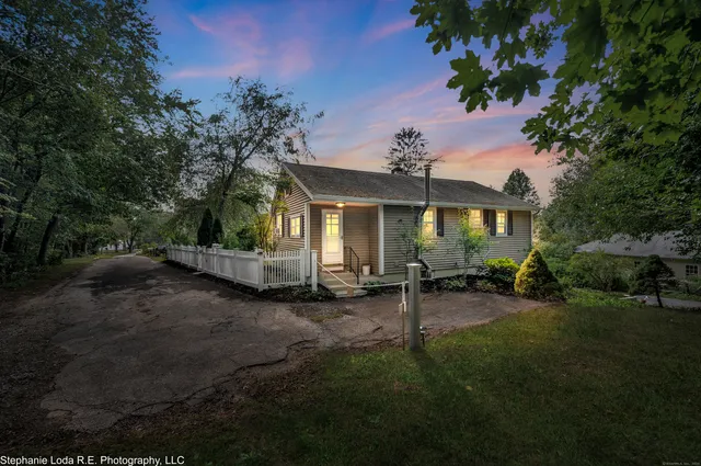 a view of a house with backyard and sitting area