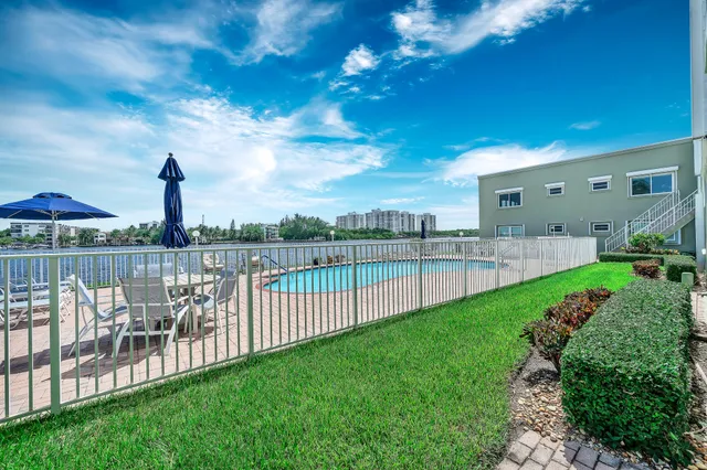 a view of a swimming pool with a patio and a yard