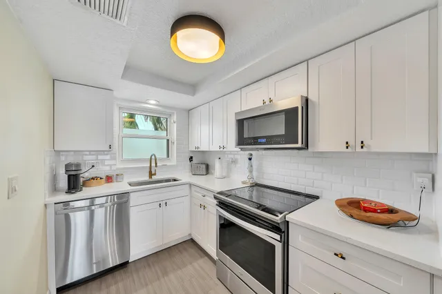 a kitchen with stainless steel appliances kitchen island granite countertop a stove a sink and a microwave