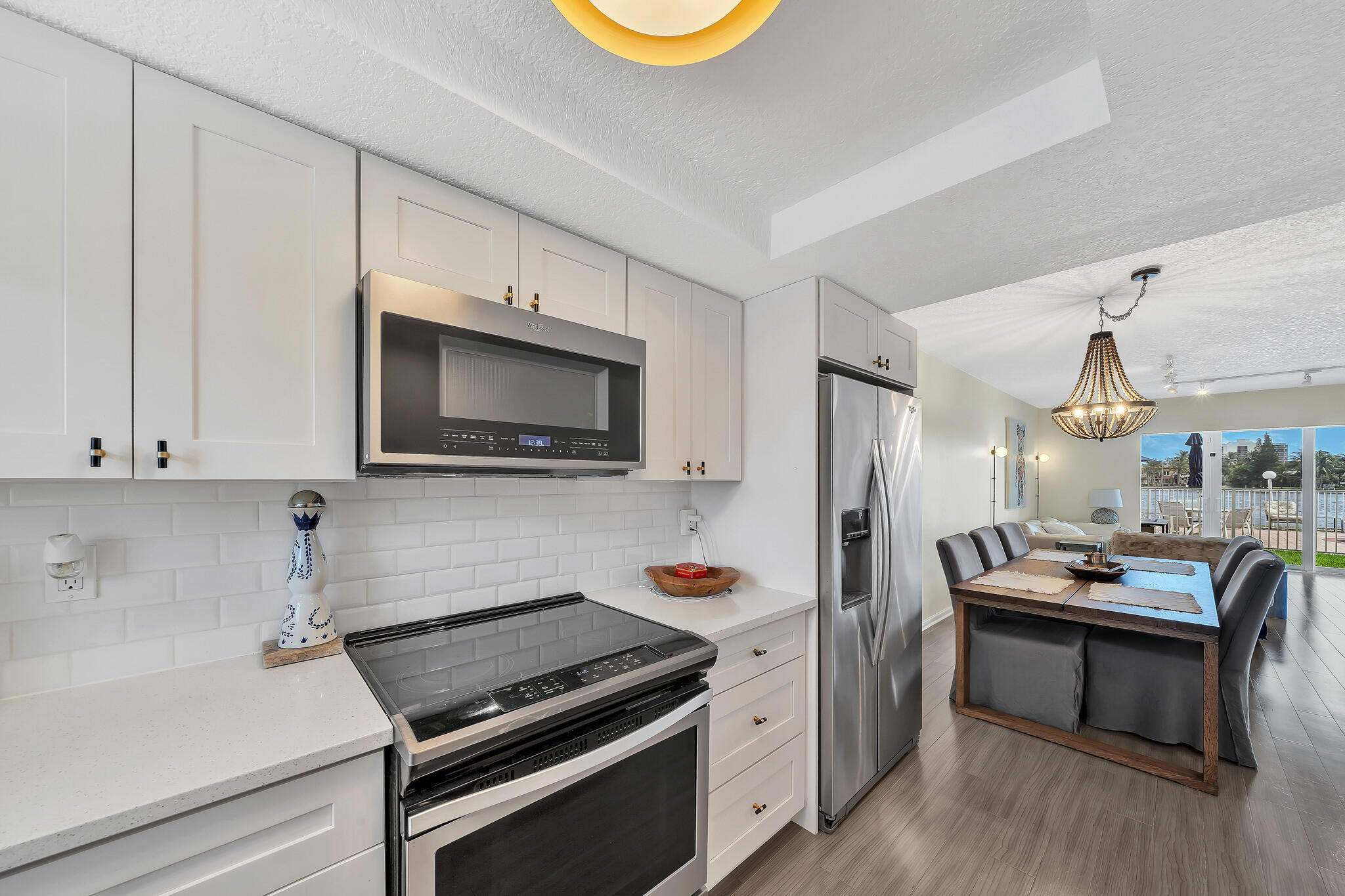 711 Northeast Harbour Terrace, Unit 3090 Boca Raton, FL 33431 - Photo 47 of 53 a kitchen with stainless steel appliances kitchen island granite countertop a stove a sink and a microwave