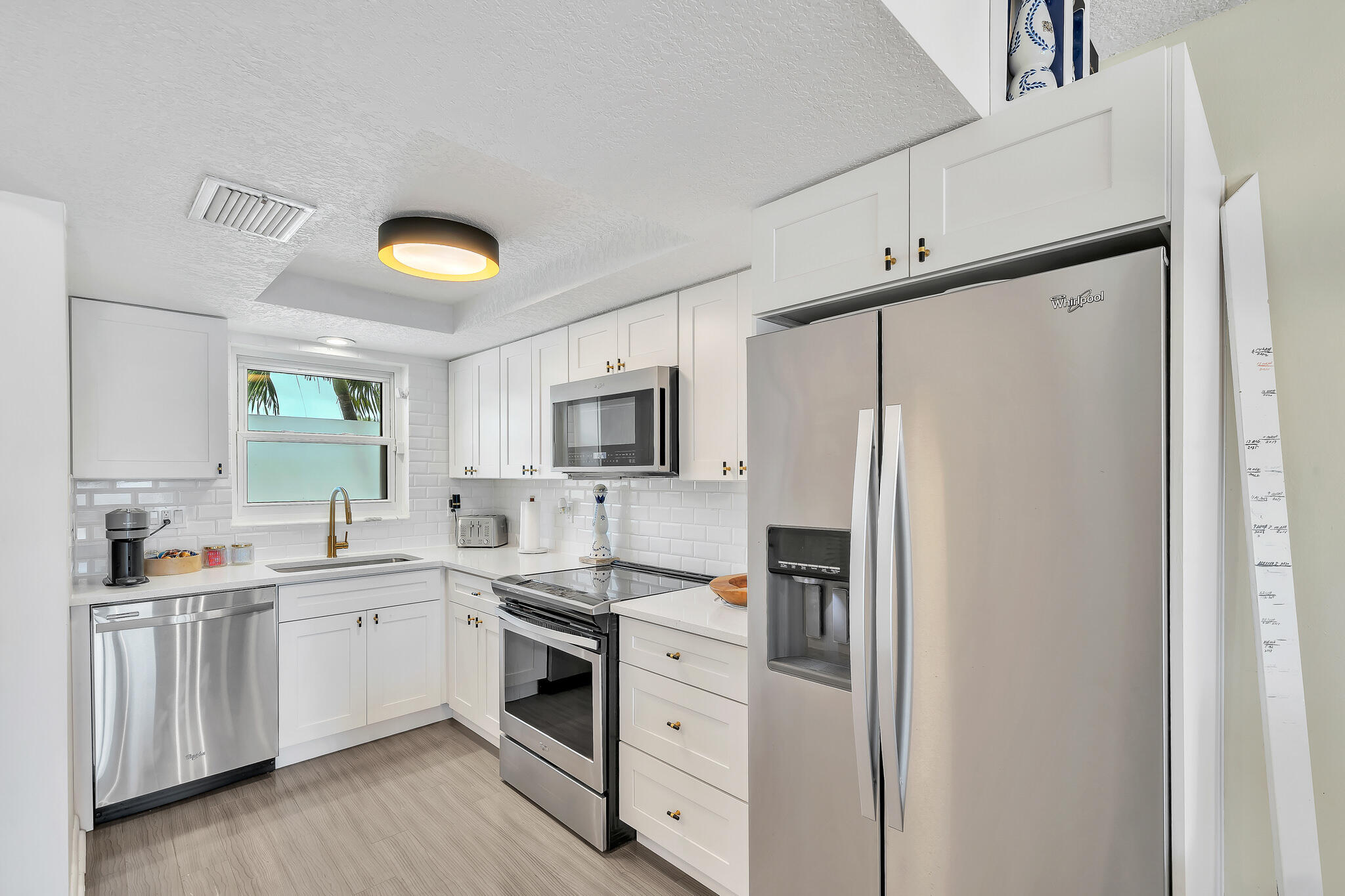 711 Northeast Harbour Terrace, Unit 3090 Boca Raton, FL 33431 - Photo 6 of 53 a kitchen with white cabinets and white appliances