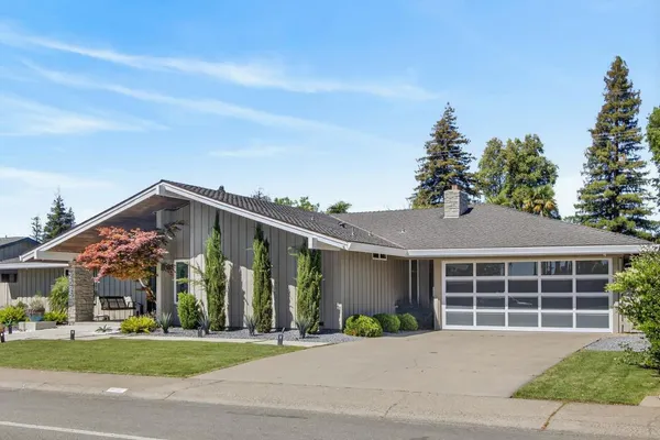 a front view of a house with a garden and plants