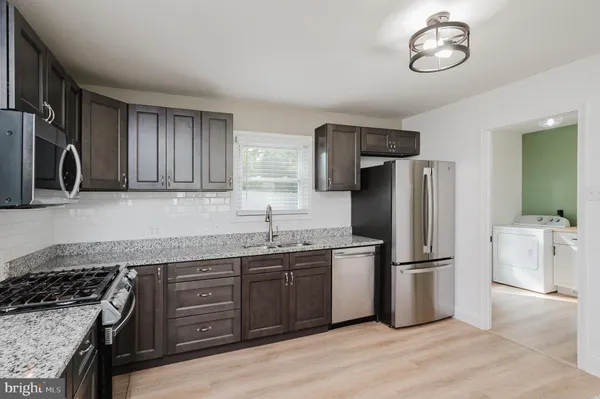 a kitchen with stainless steel appliances granite countertop a refrigerator stove and sink