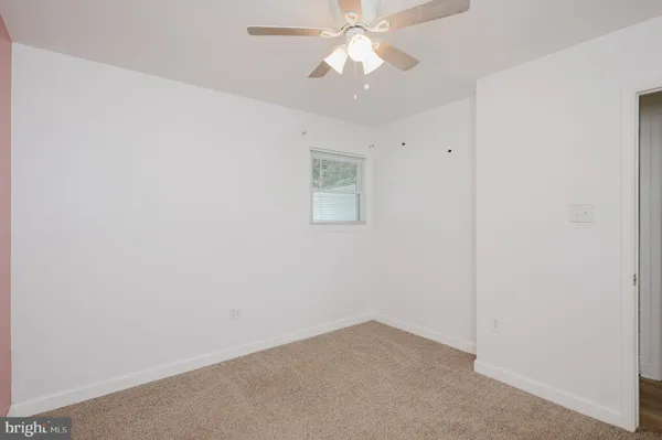 an empty room with a ceiling fan and a fan